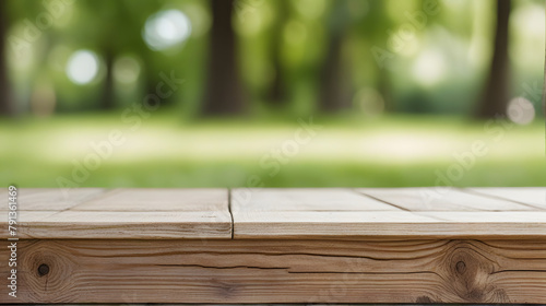 empty wooden table on grass in a sunlit park with blurred nature background