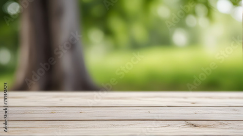 Wooden table on grass in a sunlit park with blurred nature background