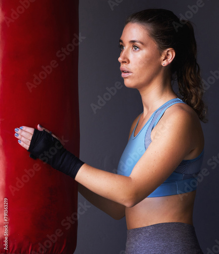 Sport, boxing bag and woman for fitness in studio as fighter training, exercise and workout in gym for competition. Active, female person and physical activity for health, wellness and self defence © peopleimages.com