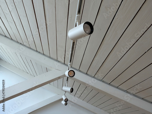 View of lights installing under the white wooden ceiling