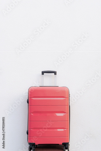 Pink travel suitcase on white background. Summer and vacations. Weekend. Travel.