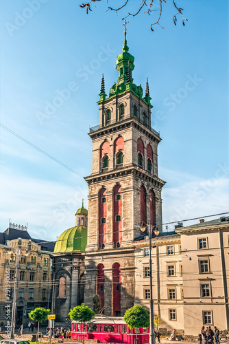 Lviv, Ukraine - November 2, 2023: Vertical view of a tram at the Street Old Book Market with the Korniakt Tower in the background in Lviv. Old Town of Lviv on an autumn morning