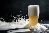 Pouring beer into glass with splashes on black background, closeup