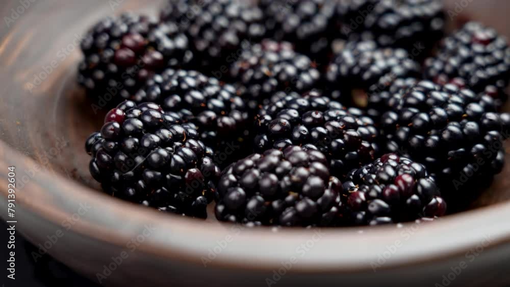 Ripe juicy organic cultivated blackberries in a rustic wooden bowl. Close up. Rotation Ripe juicy organic cultivated blackberries in a rustic wooden bowl. Close up. Rotation