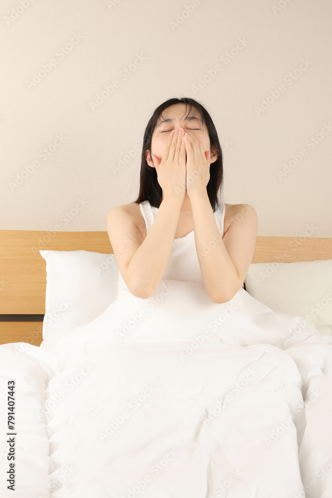 ベッドで睡眠・目覚める・あくびをする女性 ベッドで睡眠・目覚める・あくびをする女性