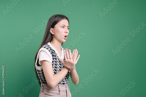 Side view of young woman showing cross hands gesture, demonstrating denial sign, rejecting something unwanted.