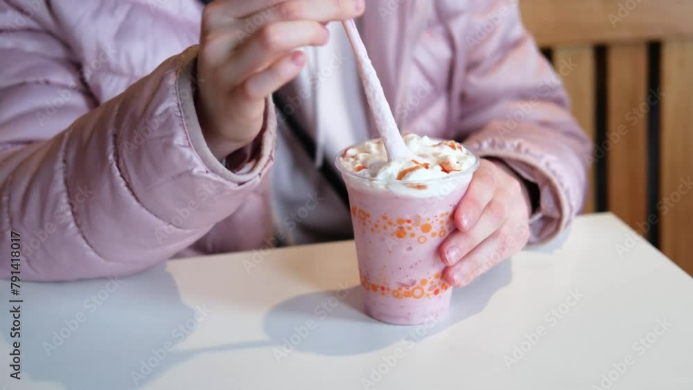 Close-up of a milkshake with cream in hand Close-up of a milkshake with cream in hand