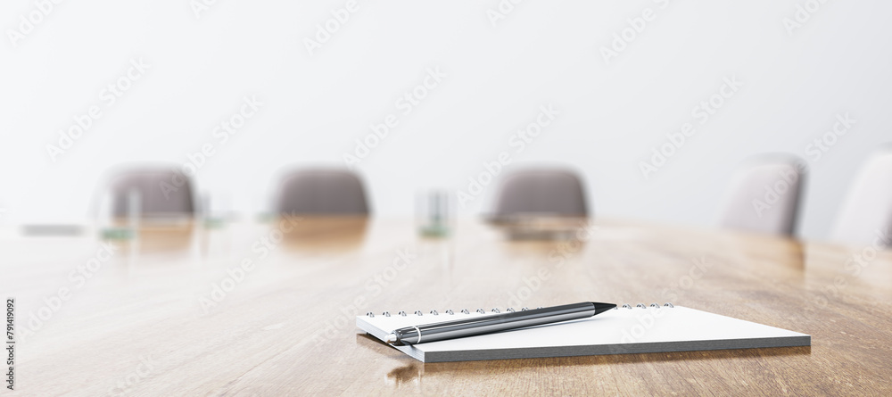 Close up of wooden conference table with empty notepad and pen for morning notes. Blurry chairs on wide background. Business meeting concept. Mock up place, 3D Rendering. Close up of wooden conference table with empty notepad and pen for morning notes. Blurry chairs on wide background. Business meeting concept. Mock up place, 3D Rendering.