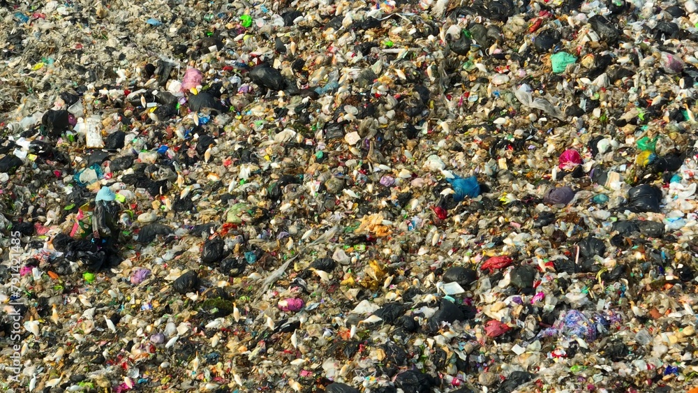 A detailed view of a landfill, showing a vast amount of mixed refuse with a variety of colors and textures, highlighting the complexity of waste management. Garbage background. Drone.
