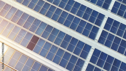 Billede på lærred Green innovation: Neatly aligned blue solar panels cover the rooftop, symbolizing the building's steadfast commitment to renewable energy