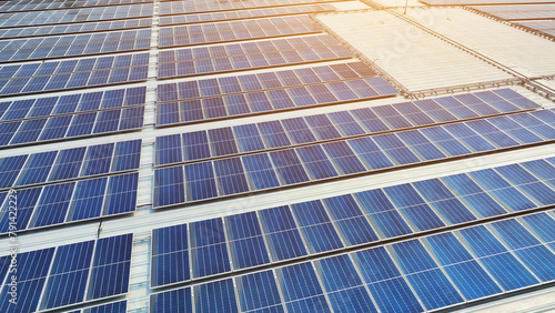 The rooftop boasts orderly arrays of sleek blue solar panels, epitomizing a dedication to sustainable energy solutions. Solar panels background. 