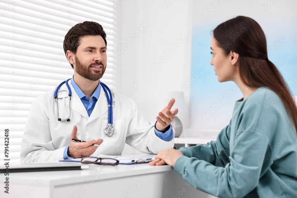 Doctor consulting patient during appointment in clinic Doctor consulting patient during appointment in clinic