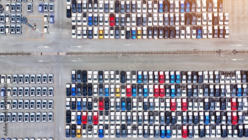 The aerial perspective unveils a meticulously arranged parking lot, a testament to automotive technological advancements, where each vehicle stands as a symbol of efficiency and progress. 