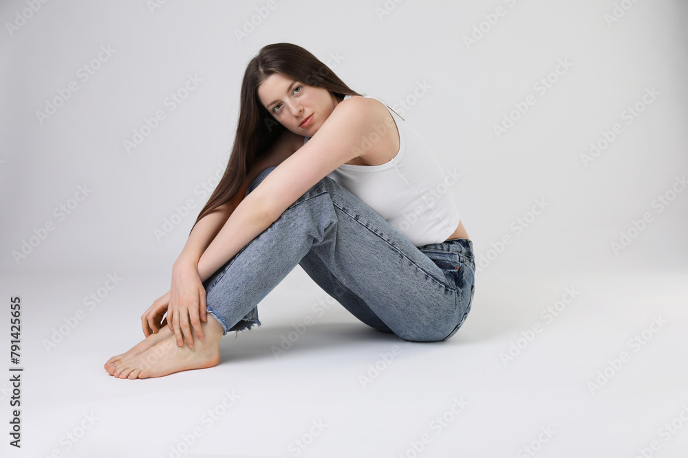 Portrait of beautiful young woman on light grey background Portrait of beautiful young woman on light grey background