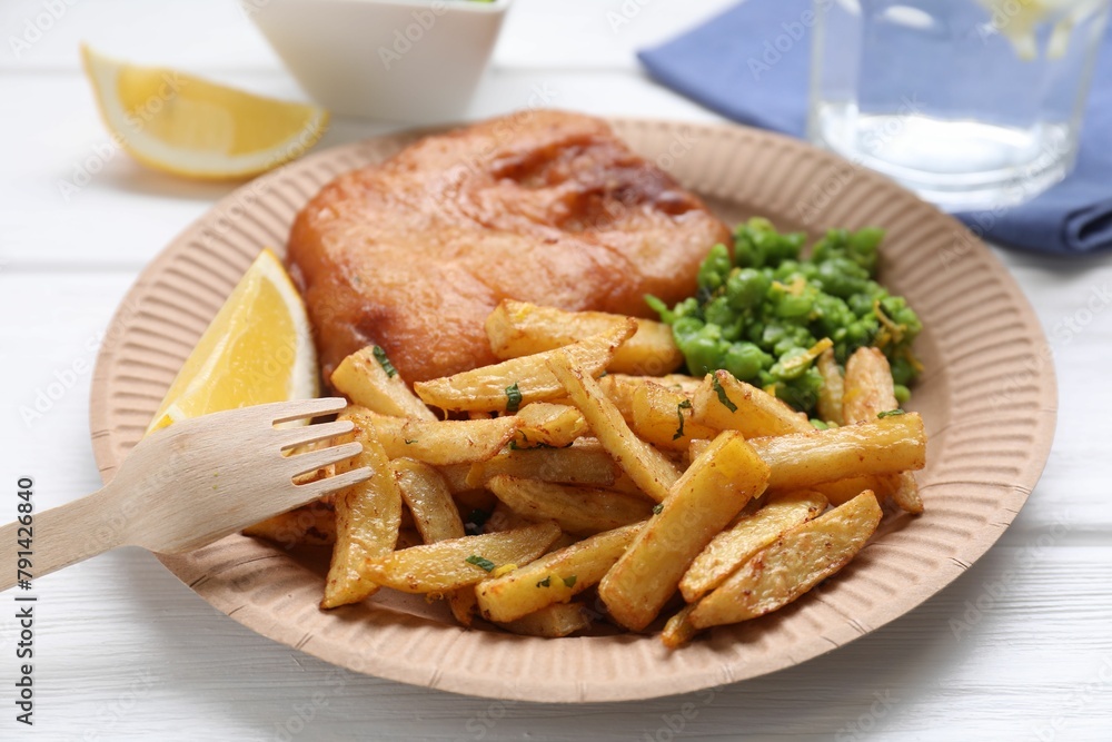 Tasty fish, chips, peas and lemon on white wooden table, closeup Tasty fish, chips, peas and lemon on white wooden table, closeup