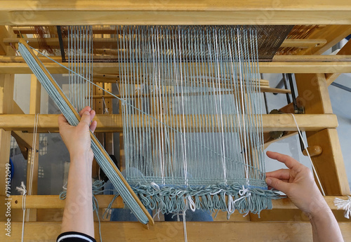 Woman's hands making tapestry on the loom with colorful wool, craftsmanship manufacturing