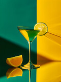 Cocktail with lemon on green and yellow background