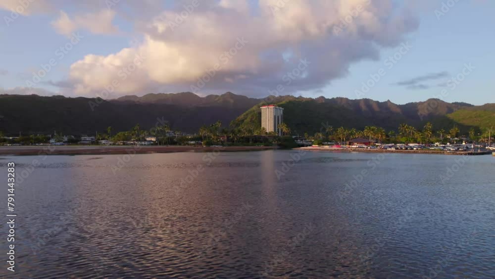stationary shot of East Honolulu Hawaii on the island of Oahu with the pink from the setting sun refecting off the water with purple mountains lining the horizon stationary shot of East Honolulu Hawaii on the island of Oahu with the pink from the setting sun refecting off the water with purple mountains lining the horizon