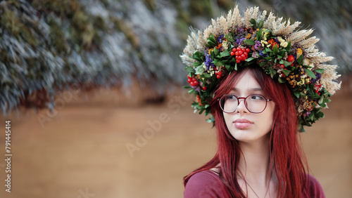 Beautiful red-haired girl in a wreath made of viburnum berries, ears of wheat, flowers and leaves © TanyaJoy