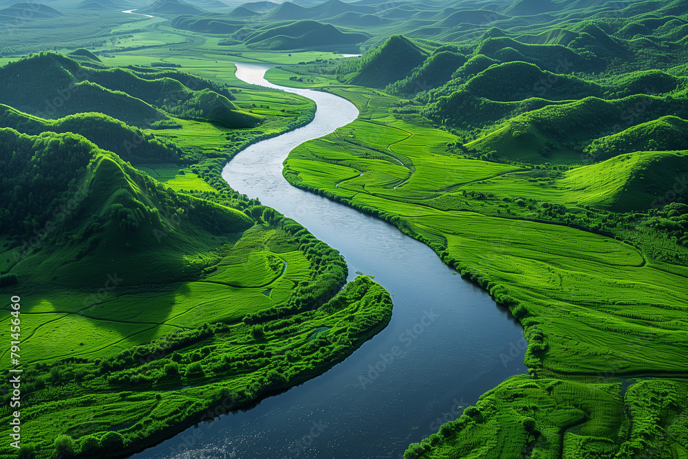 An aerial view of a winding river cutting through a lush green landscape