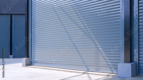 Automatic gray roller shutter entrance door of industrial warehouse building in factory area, perspective side view © Prapat