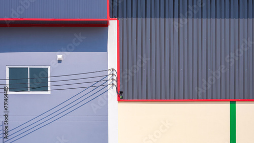 Gray aluminium steel warehouse wall next to industrial office building with electric cable lines and colorful lines pattern on surface, exterior architecture background in street minimal style 