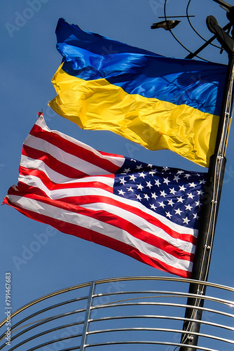 National flags of Ukraine and the United States against a blue sky