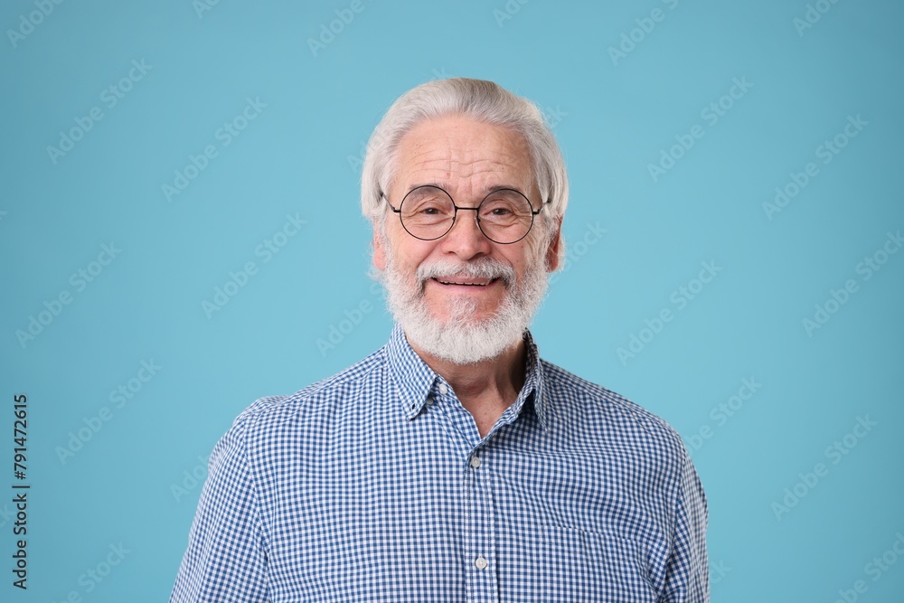 Portrait of stylish grandpa with glasses on light blue background Portrait of stylish grandpa with glasses on light blue background
