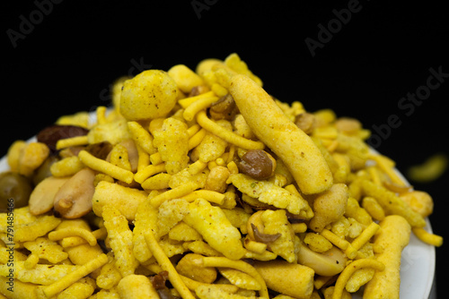 Indian Tea-time snacks like sev, chivda, farsan, mixture, boondi, bakarwadi etc served in white wooden box with cells. selective focus photo