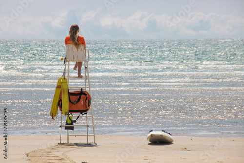 Foto maître nageuse, sauveteuse, secouriste en mer sur une chaise haute au bord de l'