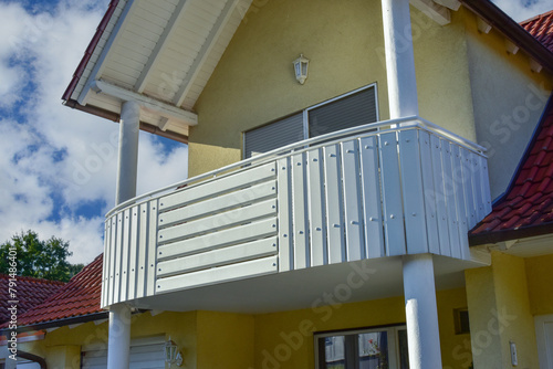 Balkon mit Metall-Geländer und lackierten Holzplanken an einem Wohnhaus