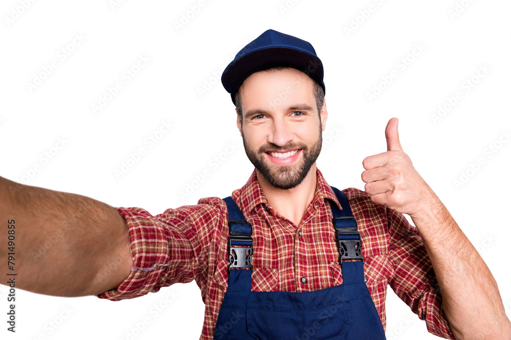 Self portrait of cheerful positive mechanic with stubble in overall, shirt shooting selfie on front camera showing thumb up yes done like sign isolated on grey background Self portrait of cheerful positive mechanic with stubble in overall, shirt shooting selfie on front camera showing thumb up yes done like sign isolated on grey background