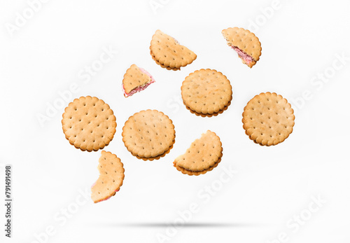 Flying white sandwich cookies with pink strawberry cream on a white isolated background