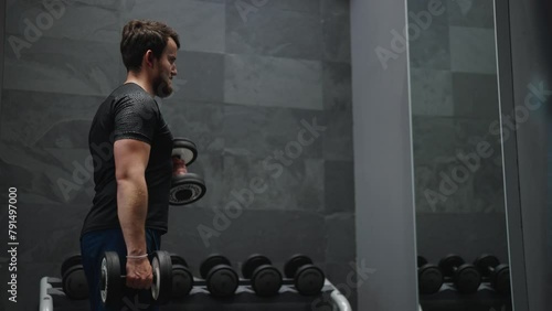 Male perform active lifestyle at gym, do standing dumbbell biceps curl photo