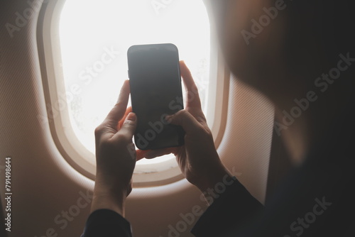 Wallpaper Mural Blonde female tourist checking incoming notification on smartphone sitting on seat of airplane with netbook.Young businesswoman share media from telephone on laptop computer during plane flight Torontodigital.ca