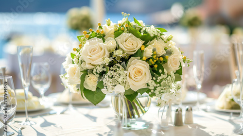 Classic white rose wedding centerpiece on a banquet table.