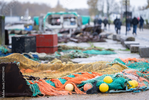 Heap of colourful trawling fishing nets and floats on the quay at harbour. Fishing nets on the harbor quay. 