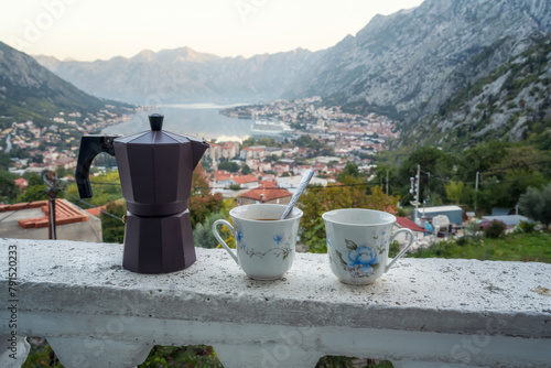 A pair of coffee cups and a coffee maker on the ledge of the terrace of a room with an amazing panoramic view of the picturesque Bay of Kotor and Montenegro