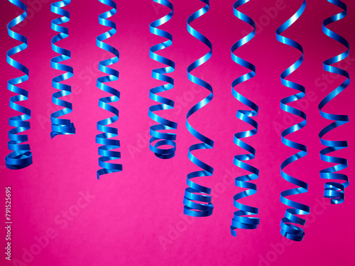 decorative blue streamer ribbons on pink background