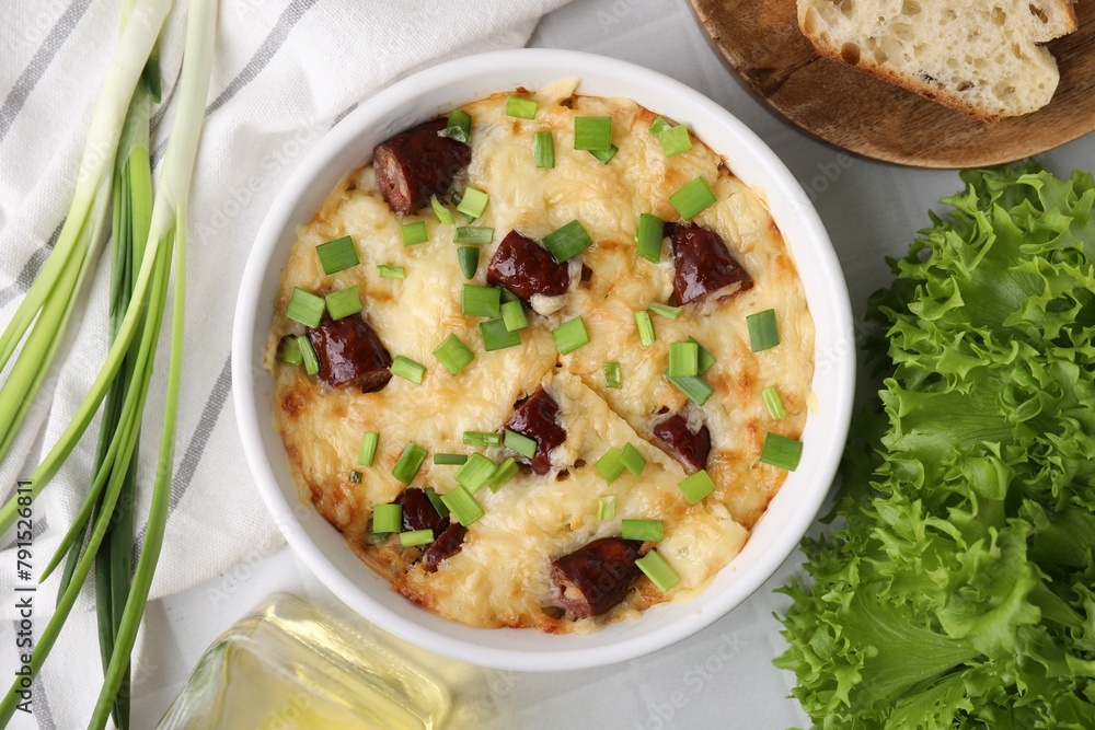 Tasty sausage casserole in baking dish served on white tiled table, flat lay Tasty sausage casserole in baking dish served on white tiled table, flat lay