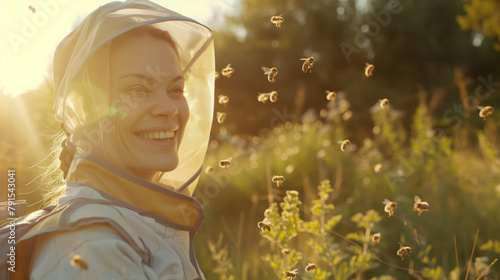 A female beekeeper stands by the forest surrounded by bees. Beekeeping is the oldest branch of agriculture, which is engaged in breeding bees to produce honey photo