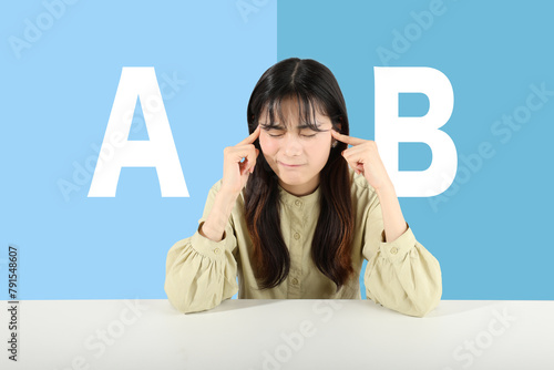 AかBか、どちらか悩む若い女性　ブルー