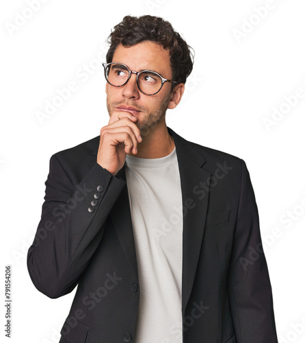 Young Hispanic businessman looking sideways with doubtful and skeptical expression. photo