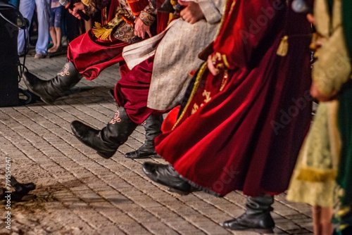 Boots of the Ukrainian Cossacks close-up with red long coats in the dance	
 photo