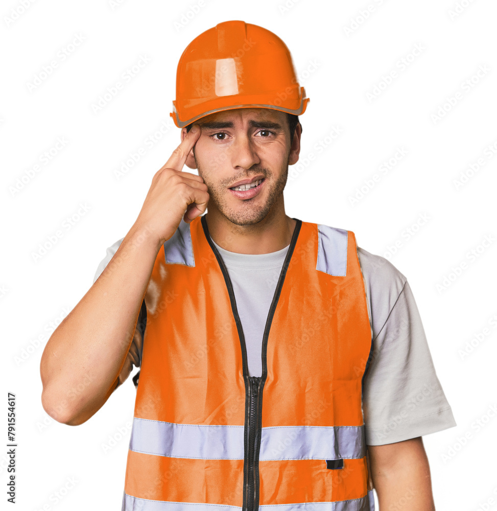 Young Hispanic worker in safety gear showing a disappointment gesture with forefinger. Young Hispanic worker in safety gear showing a disappointment gesture with forefinger.