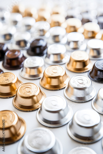 Espresso coffee capsules in varied hues rest on white. Background fades to soft focus. Concept of morning refreshment choices. Close up. Vertical