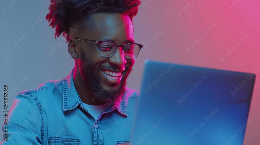 Fototapeta premium Man Smiling at Colorful Laptop Screen