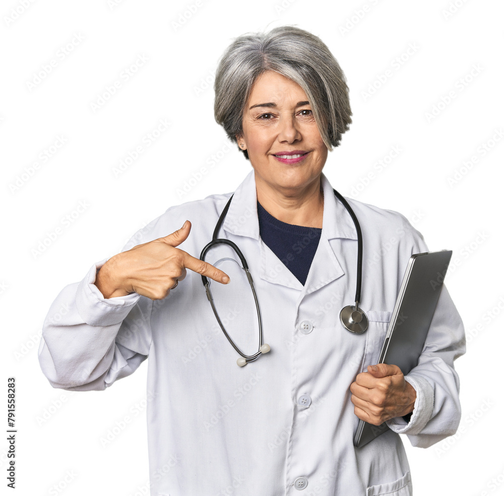 Caucasian mid-age doctor holding laptop person pointing by hand to a shirt copy space, proud and confident Caucasian mid-age doctor holding laptop person pointing by hand to a shirt copy space, proud and confident