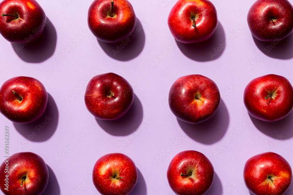 Many red apples on colored background, top view. Autumn pattern with fresh apple above view
