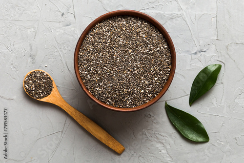 Chia seeds in bowl and spoon on colored background. Healthy Salvia hispanica in small bowl. Healthy superfood photo